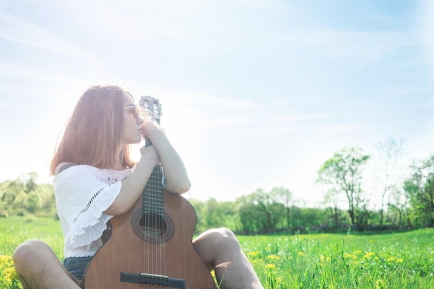 写真 空の向こうのフィールドに座っている女性の後ろの景色