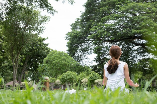 写真 フィールドに座っている女性の後ろの景色