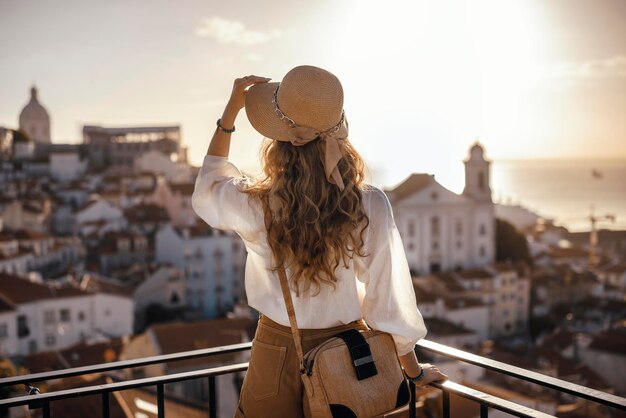 写真 街の空に向かって立っている女性の後ろの景色