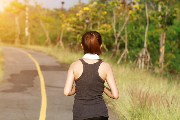 写真 樹木に寄りかかって立っている女性の後ろの景色