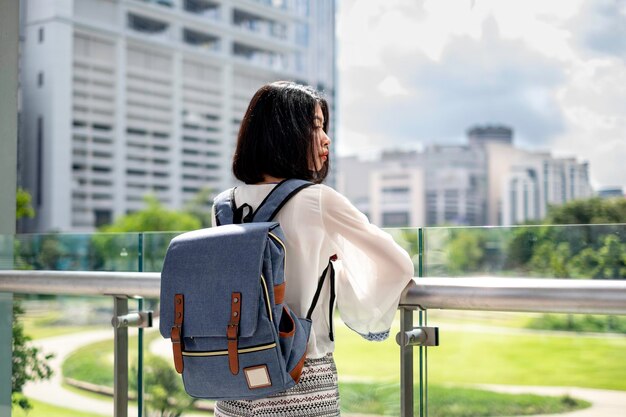 写真 街の建物のレールに立っている女性の後ろの景色