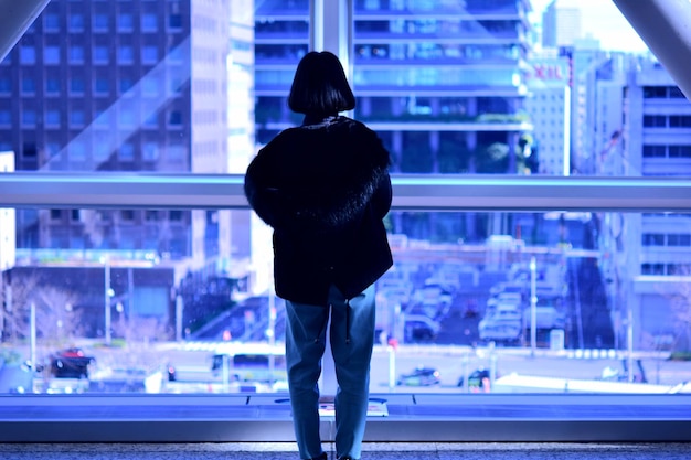 写真 夜街に立っている女性の後ろの景色