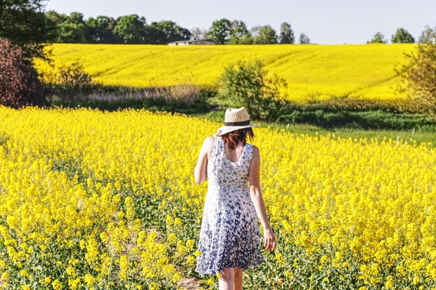 写真 空の向こうのフィールドに立っている女性の後ろの景色