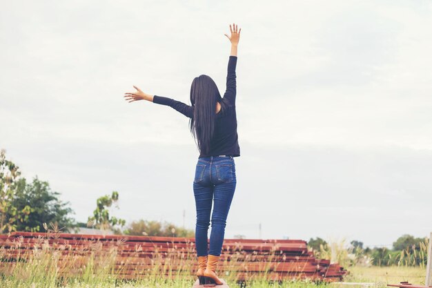 写真 空の向こうのフィールドに立っている女性の後ろの景色