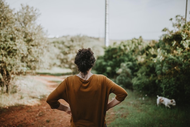 写真 空の向こうのフィールドに立っている女性の後ろの景色