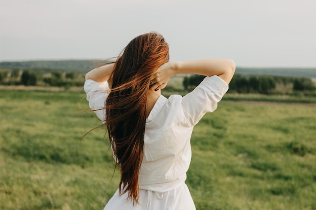 写真 フィールドに立っている女性の後ろの景色