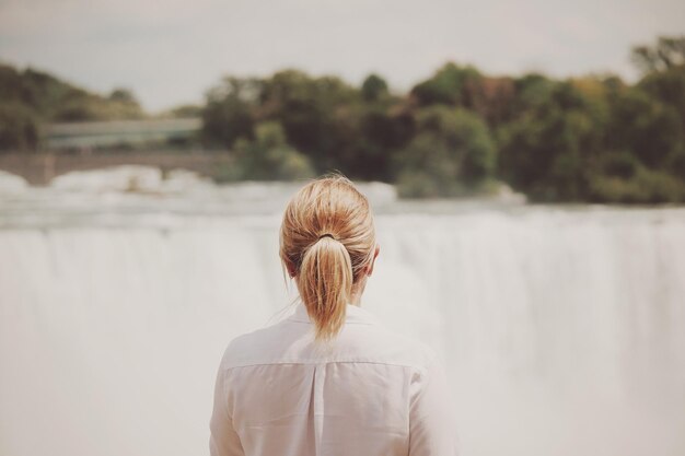 写真 フィールドに立っている女性の後ろの景色