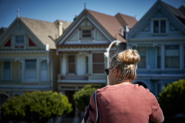 写真 家の外に立っている女性の後ろの景色