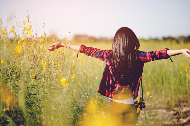 写真 空に向かって畑を歩く女性の後ろの景色