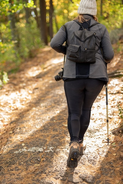 写真 森の歩道を歩く女性の後ろの景色