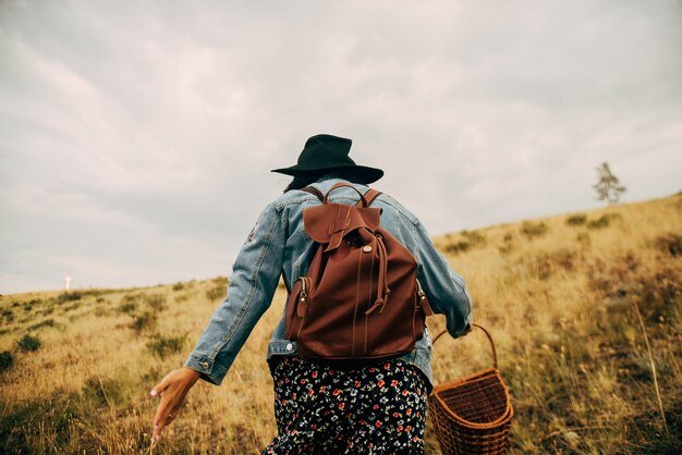 写真 空に向かって陸上を歩く女性の後ろの景色