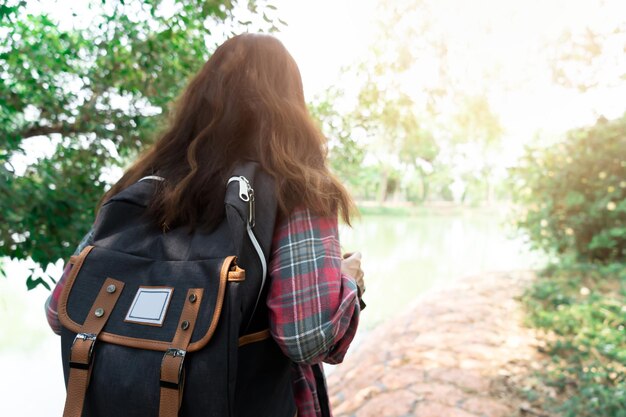 写真 樹木に背包を背負った女性の後ろの景色