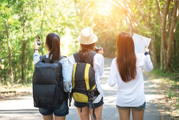 사진 나무 들 사이 의 보행길 에 서 있는 여자 들 의 뒷면