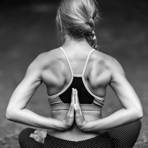 Фото Задний вид молодой женщины, практикующей йогу в парке