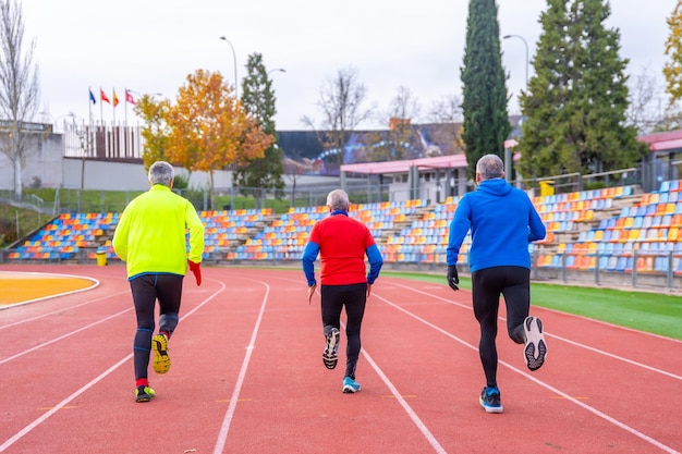 Rear view of old man sprinting in an athletics tack