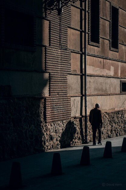 건물 벽 에 있는 도시 를 걸어다니는 노인 의 뒷면