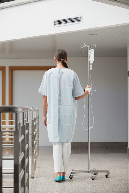 Rear view of a patient holding a drip stand