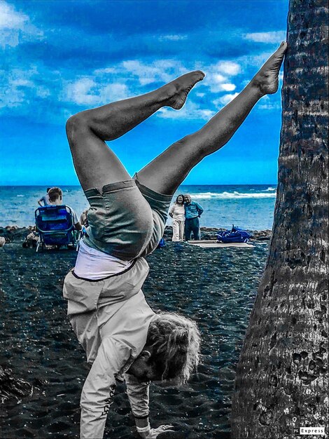 Rear view of people at beach against sky