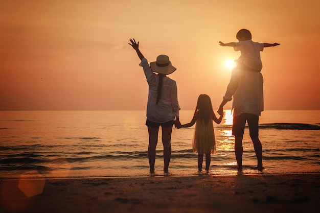 Photo rear view of people on beach at sunset