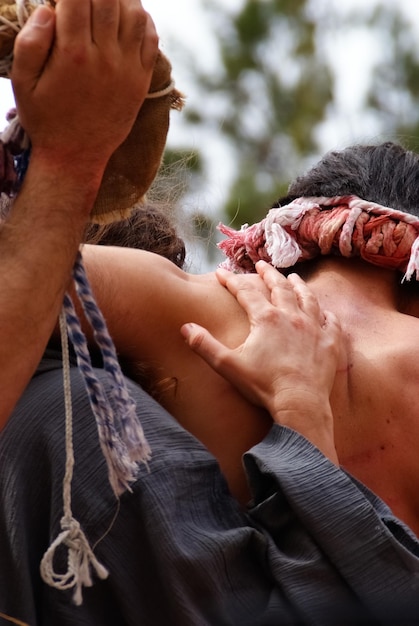 Photo rear view of people carrying man for crucifix outdoors