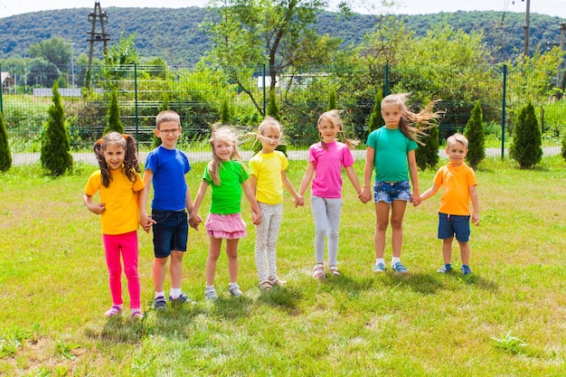 Foto vista posteriore di persone che si divertono sull'erba contro le piante