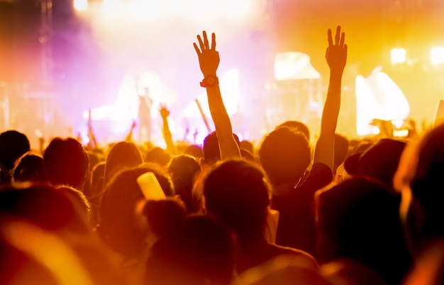 Photo rear view of people enjoying at music concert