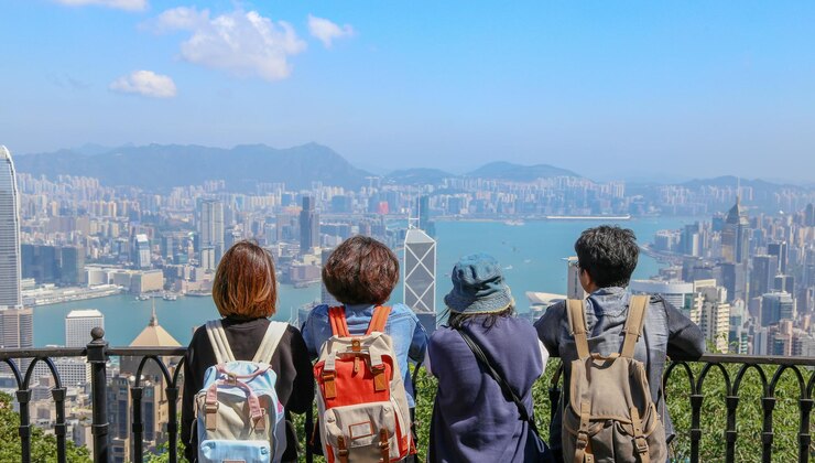 Photo rear view of people looking at cityscape against sky while standing by railing