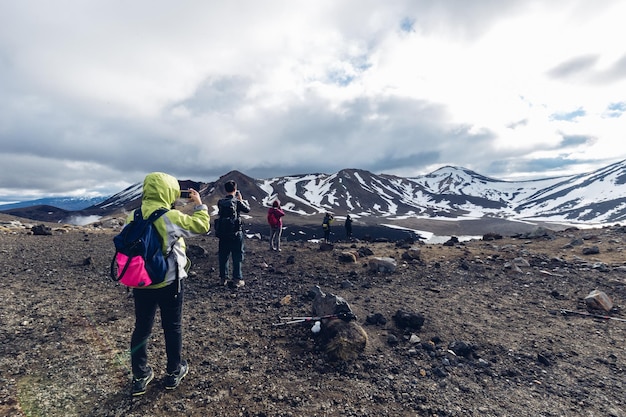 天空を背景に山の上にいる人々の後ろの景色