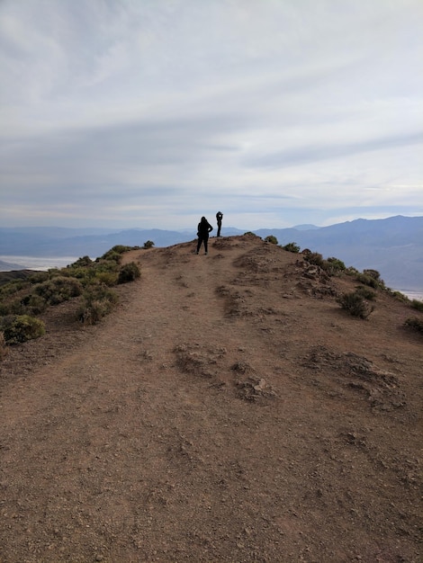 Rear view of people on mountain against sky