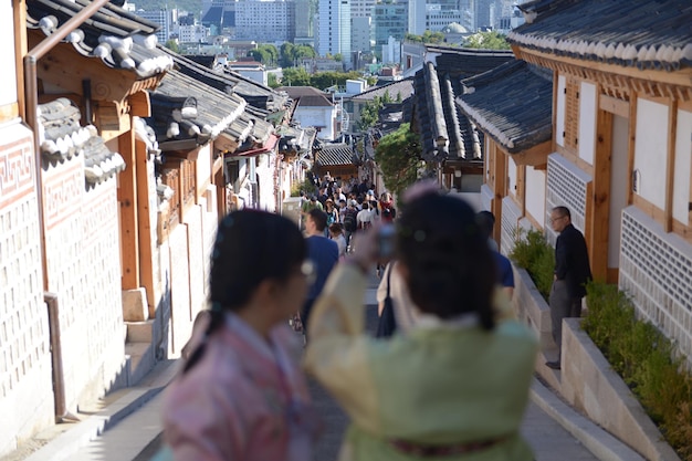 rear view of people photographing on street amidst buildings in city