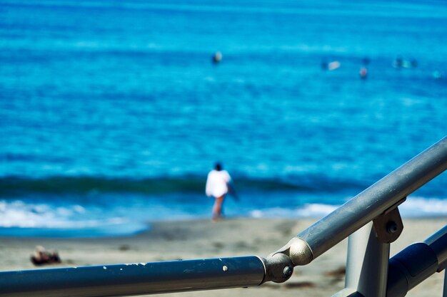 Rear view of people on sea shore against sky