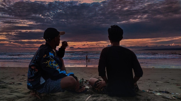 Rear view of people sitting on beach