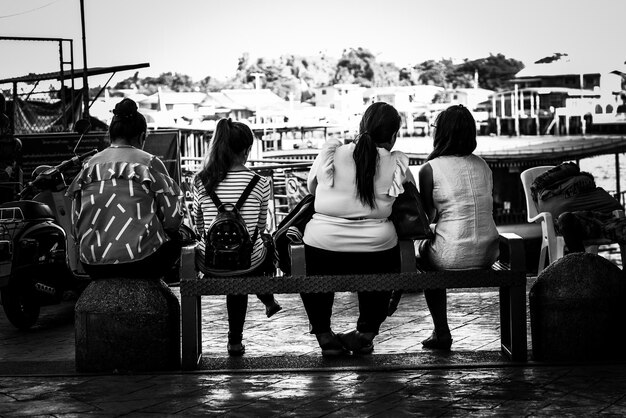 Rear view of people sitting on bench