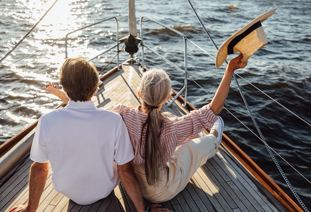 Photo rear view of people sitting on boat in sea