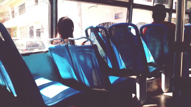 Photo rear view of people sitting on seats in bus