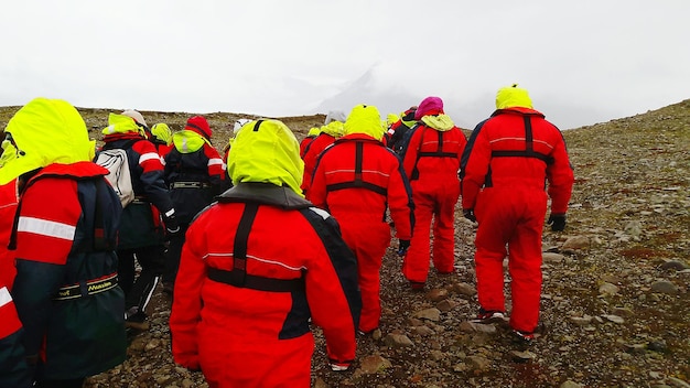 Rear view of people standing against sky