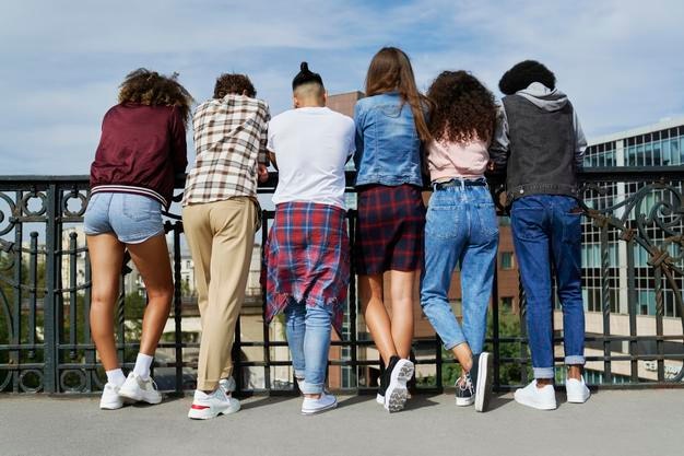 Rear view of people standing in front of the railing