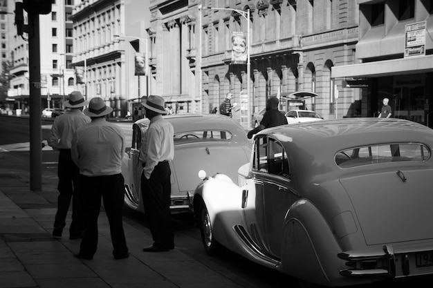 rear view of people standing next to vintage car