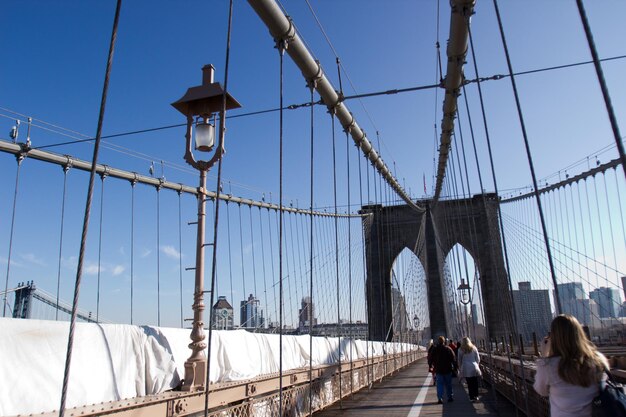 Rear view of people walking on bridge against sky