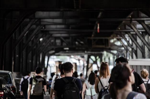 Photo rear view of people walking in covered bridge