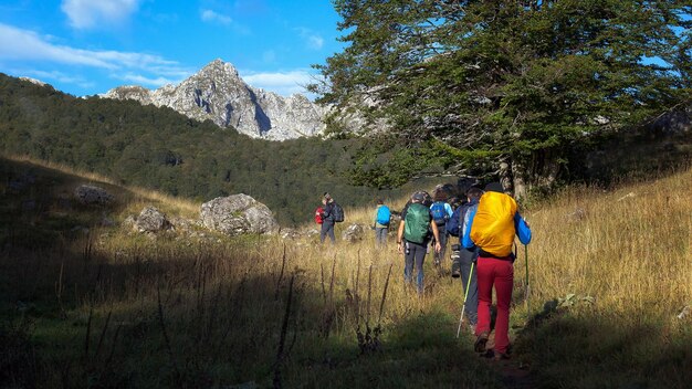 Foto vista posteriore di persone che camminano sul campo contro il cielo