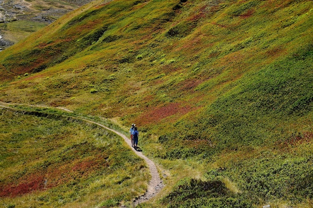 山を歩く人々の後ろの景色