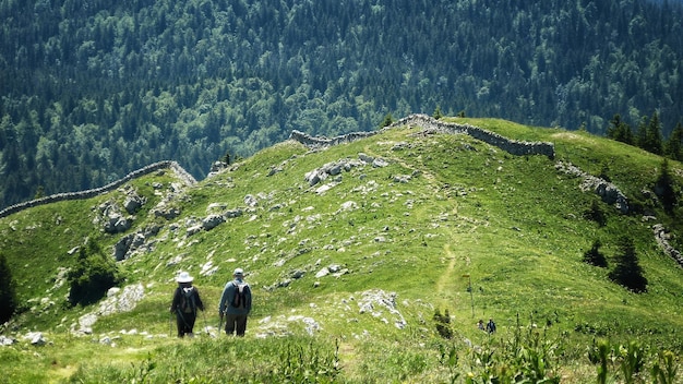 山を歩く人々の後ろの景色