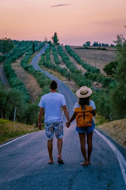 Rear view of people walking on road against sky