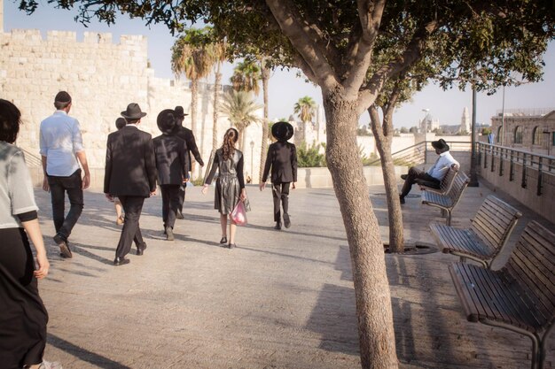 Photo rear view of people walking on sidewalk in city