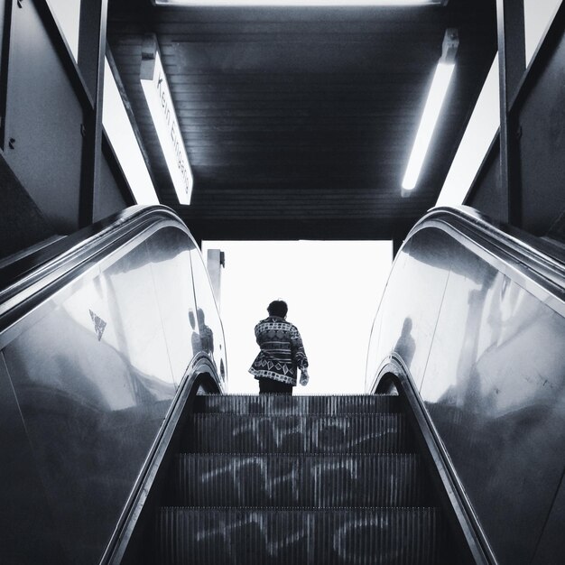 Rear view of person on escalator