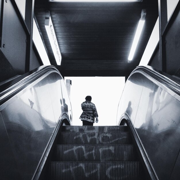 Photo rear view of person on escalator