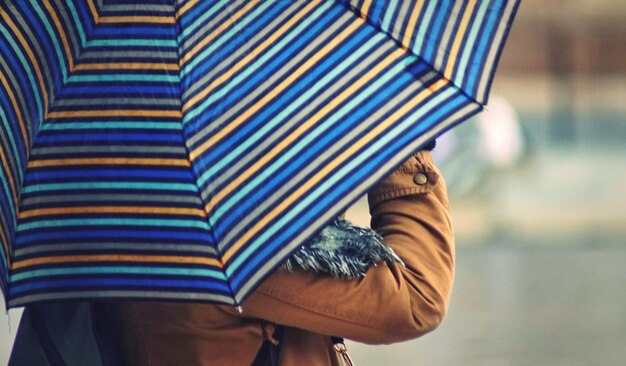 Foto vista posteriore di una persona che tiene un ombrello