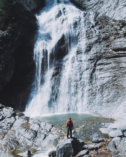 Photo rear view of person looking at waterfall