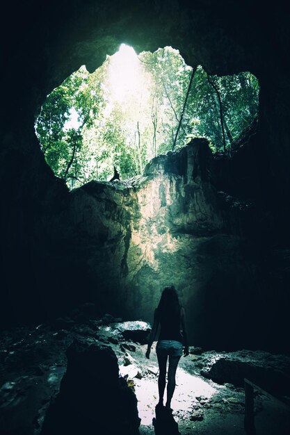 Foto vista posteriore di una persona in piedi nella grotta